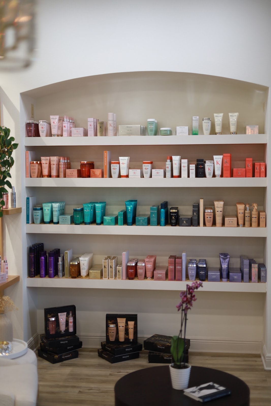 Arched retail shelving displaying the full Kérastase product range at Musart Salon