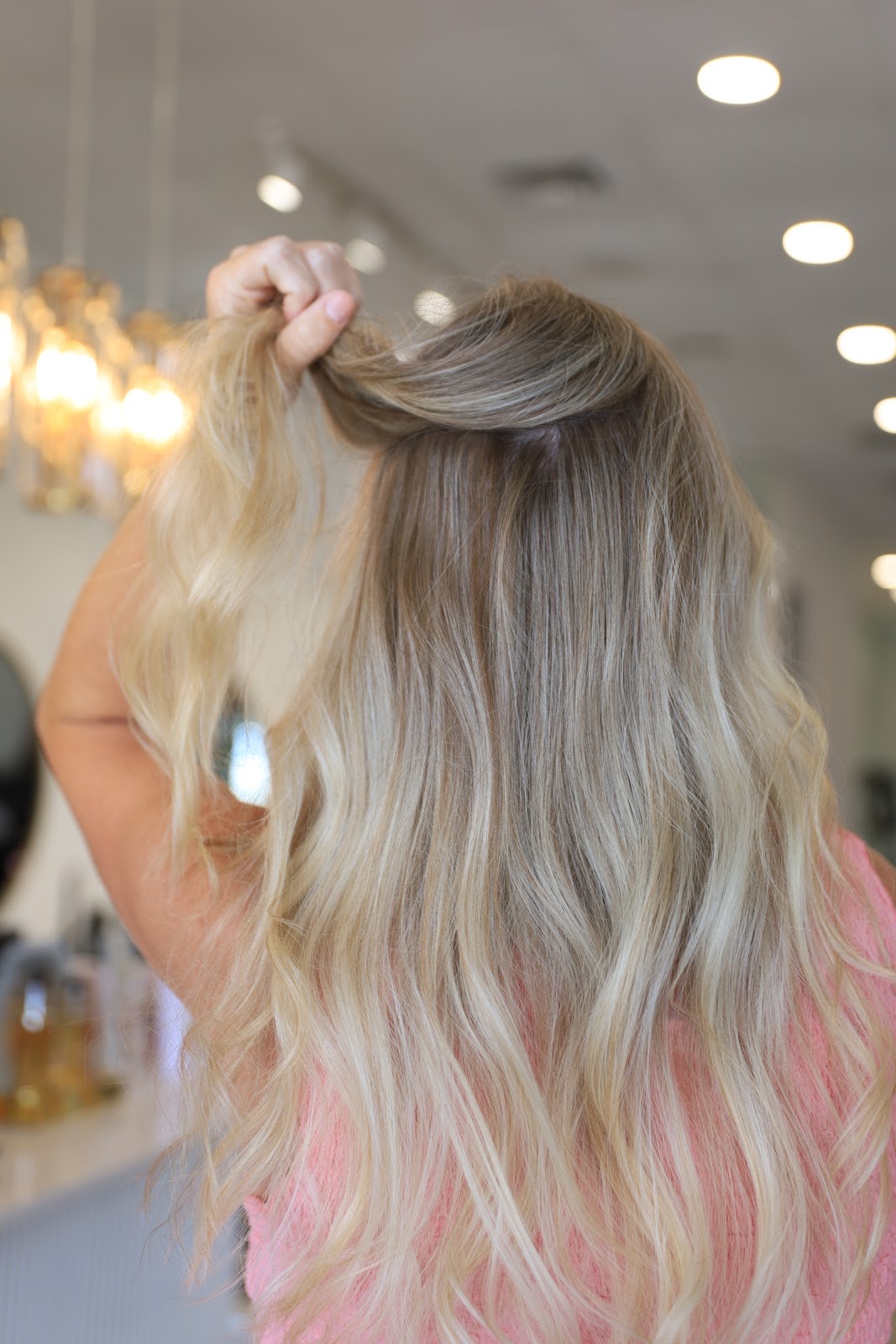 Long blonde balayage hair styled in soft waves at Musart Salon